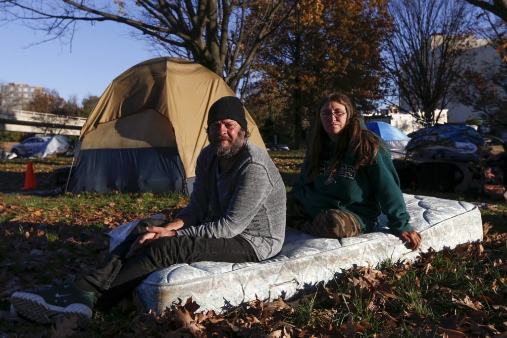 Clyde Burgit and his wife Helen, who have been at the camp for two weeks, sit on a mattress near their tent by the Watergate and Whitehurst Freeway in Washington D.C., November 16, 2015. "Everybody looks out for everybody, this was great and everybody gets along," Clyde said.On November 20, 2015 the residents were evicted from the area, according to local reports. REUTERS/Shannon Stapleton PICTURE 34 OF 35 - SEARCH "STAPLETON TENTS" FOR ALL IMAGES