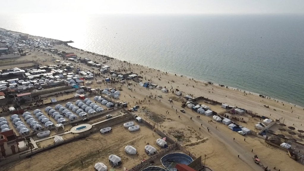 A drone view of Palestinians gathering on a beach in the hope of getting aid air-dropped over Gaza is seen, amid the ongoing the conflict between Israel and Hamas, in Deir Al-Balah in the central Gaza Strip February 26, 2024. REUTERS/Amjad Abu Sharia