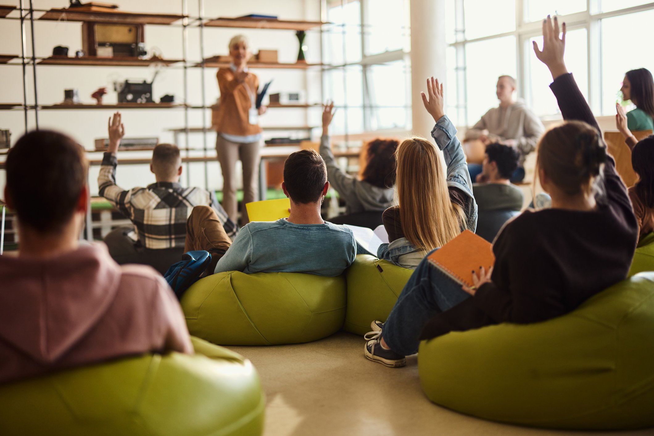 teen students raising their hands