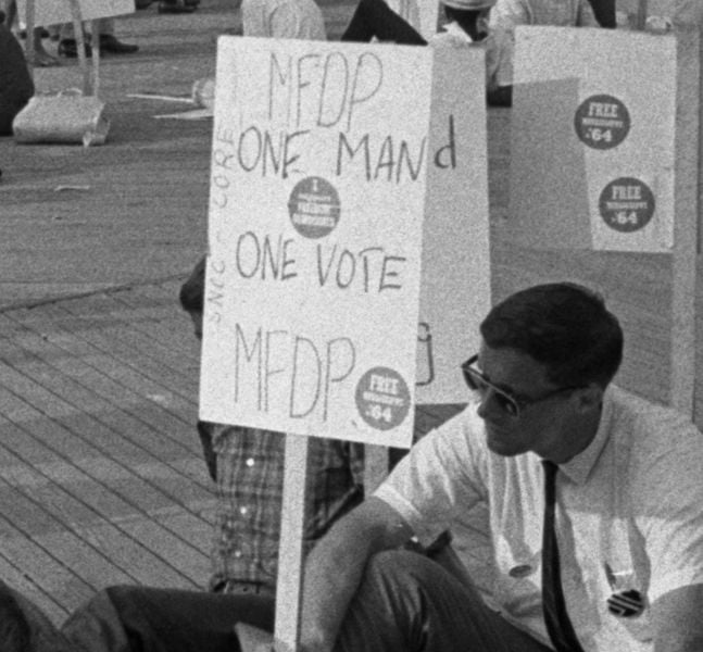 African American and white supporters of the Mississippi Freedom Democratic Party holding signs in front of the convention hall at the 1964 Democratic National Convention, Atlantic City, New Jersey; some signs read: One man, one vote, MFDP