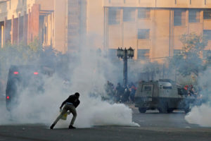 Chile Protests: A demonstrator covers a tear gas canister in a bucket during a protest against Chile’s state economic model in Santiago, Chile Oct. 26, 2019. REUTERS/Henry Romero